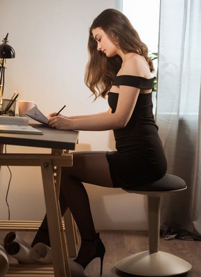 Цыпочка в черных чулках раздвигает ноги на столе